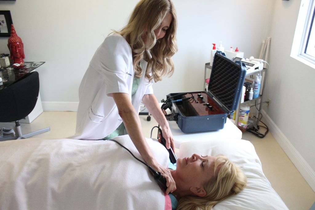 Ana operating a medical device on a patient during treatment.