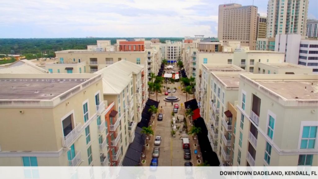 Aerial view of Downtown Dadeland in Kendall, FL, featuring a vibrant cityscape with buildings and moving cars.