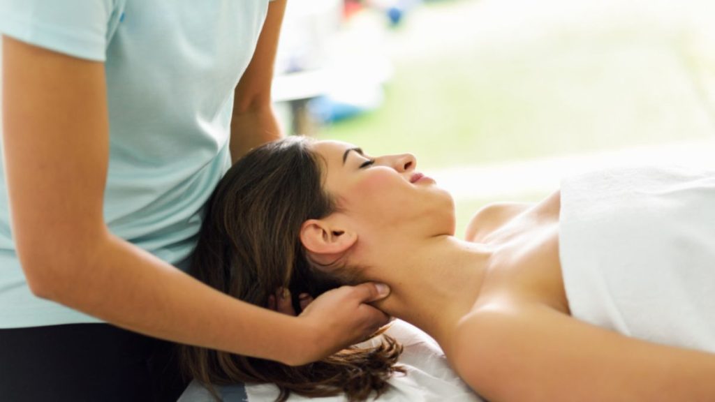 A woman receives a therapeutic massage in a tranquil setting, enhancing her relaxation and well-being.