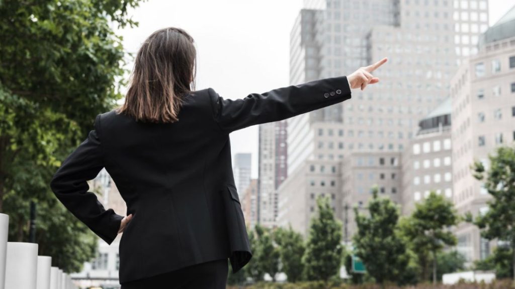 A woman in a business suit is gesturing, symbolizing career transition coaching services in Miami.