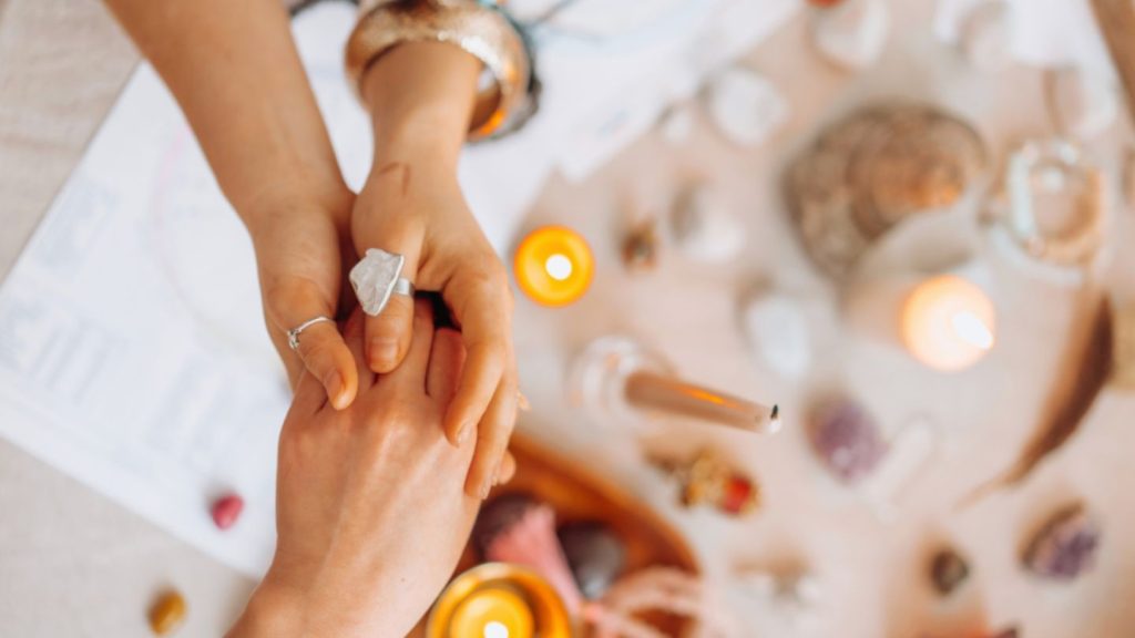A woman displays a ring on her hand, representing chakras and her journey in spiritual life coaching.