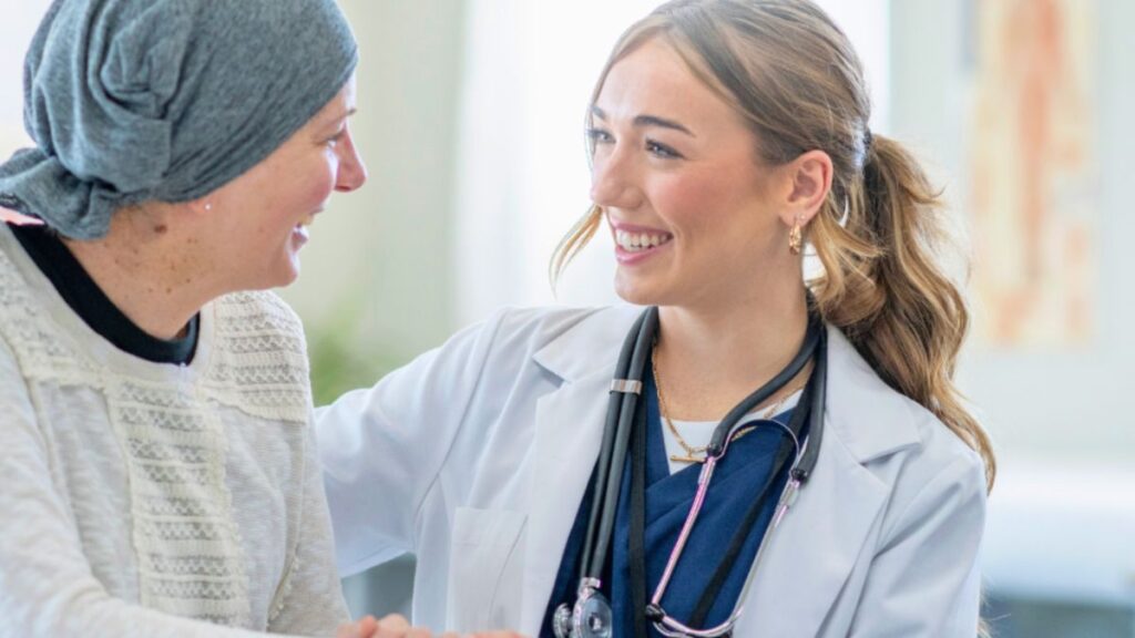 A woman engages in conversation with a doctor about lymphedema therapy as part of her cancer care education.